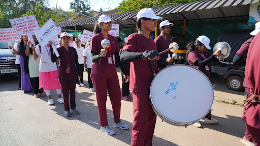 M.I.O. staff beat drums and carry awareness placards through Koppa's main roads
