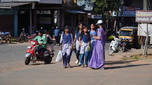 An M.I.O. team member pauses the march to speak directly with young women on Koppa's streets