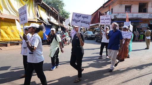 M.I.O. staff and volunteers carry cancer awareness placards through Kumta's main roads during the "Arive Shakthi" rally