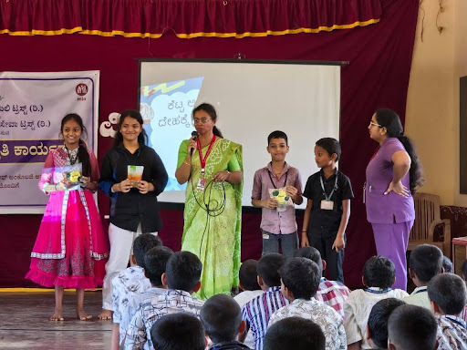 Students and M.I.O. staff take the stage together at Ammunje Aided School for an interactive role-play