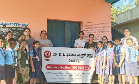 The M.I.O. Thirthahalli team joins students and staff for a group photo outside Government Higher Primary School, Seebinakere