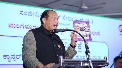 Mr. Ivan D'Souza, MLC, Government of Karnataka, holds up the 10,000+ Household Cancer Awareness Survey Report at the release event in Mangaluru