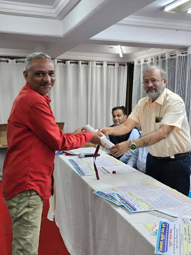 Dr. D. Suresh Rao presents campaign materials during the launch of the Cancer Household Survey in Shivamogga
