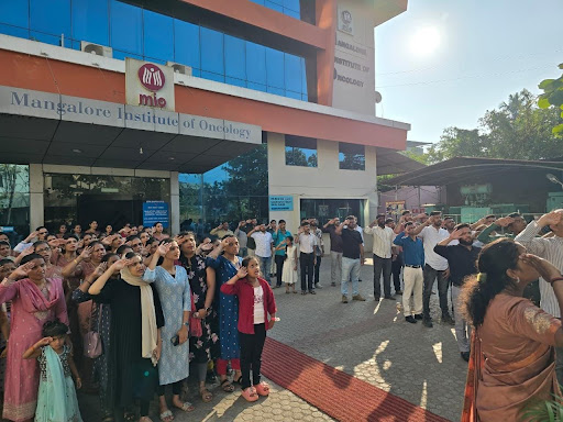 M.I.O. Pumpwell team stands at salute as the national flag is unfurled outside the hospital building